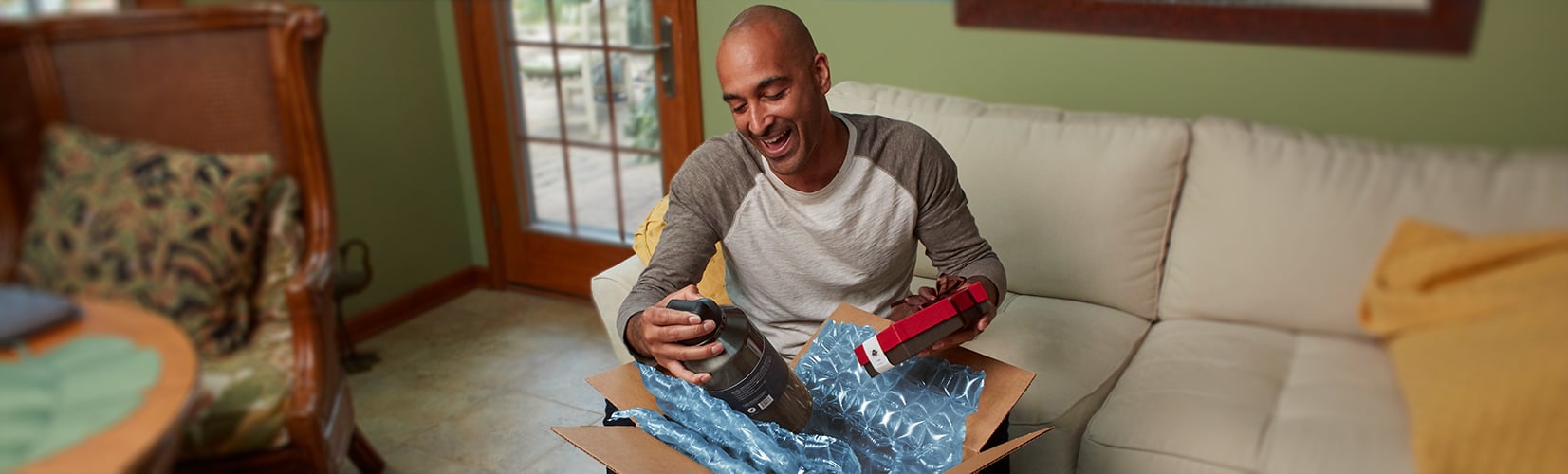 Person opens box package with custom blue Hybrid Cushioning protection