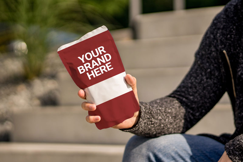 A person holds custom packaging labelled "Your Brand Here" .