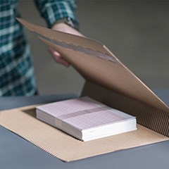 A cohesive mailer box is used to pack a book.