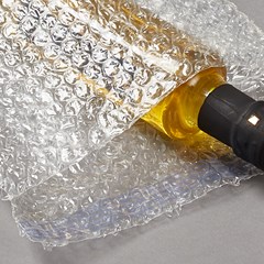 A bottled product is placed inside a clear bubble bag.