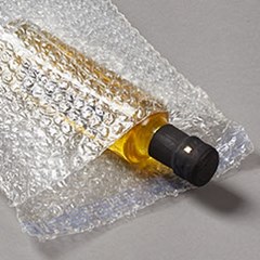 A bottled product is inside a protective bubble pouch.