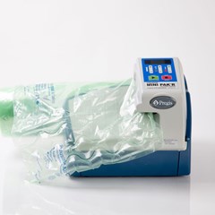 A MINI PAK'R® machine is loaded with a green roll of packaging film.