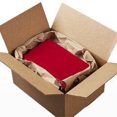A red package is being protected by paper void fill inside a cardboard box.