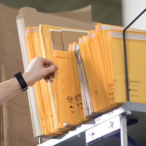 An array of shipping mailers is placed on top of a workstation.