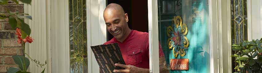 A person happily receives a parcel protected by Pregis' thin customized packaging.